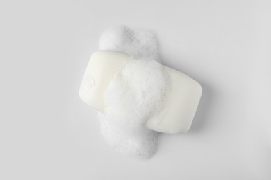 Photo of Soap with fluffy foam on white background, top view