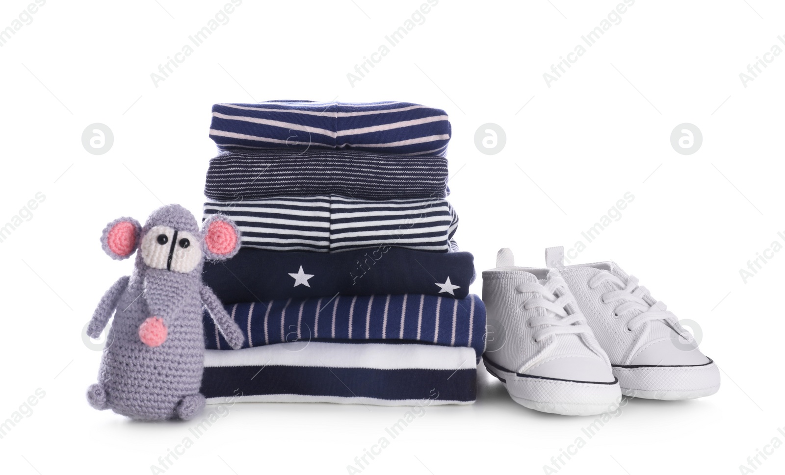 Photo of Stack of clean baby's clothes, toy and small shoes on white background