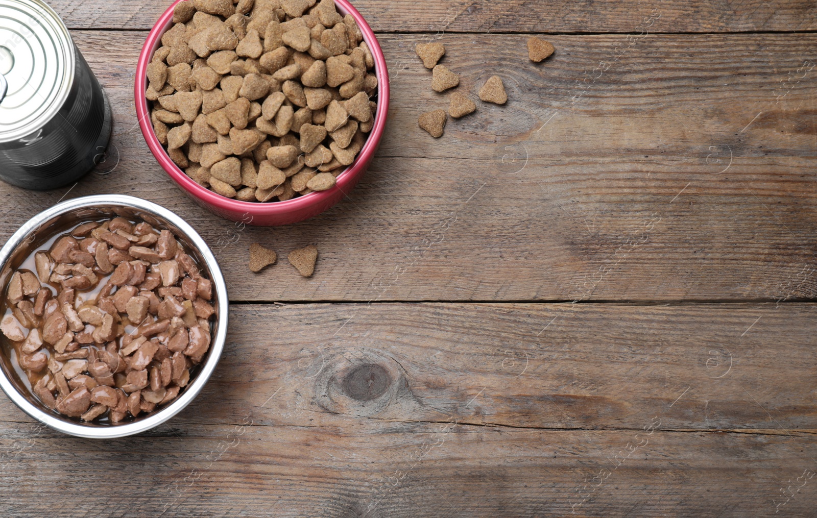 Photo of Wet and dry pet food on wooden table, flat lay. Space for text