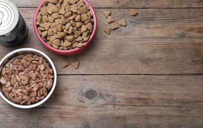 Photo of Wet and dry pet food on wooden table, flat lay. Space for text