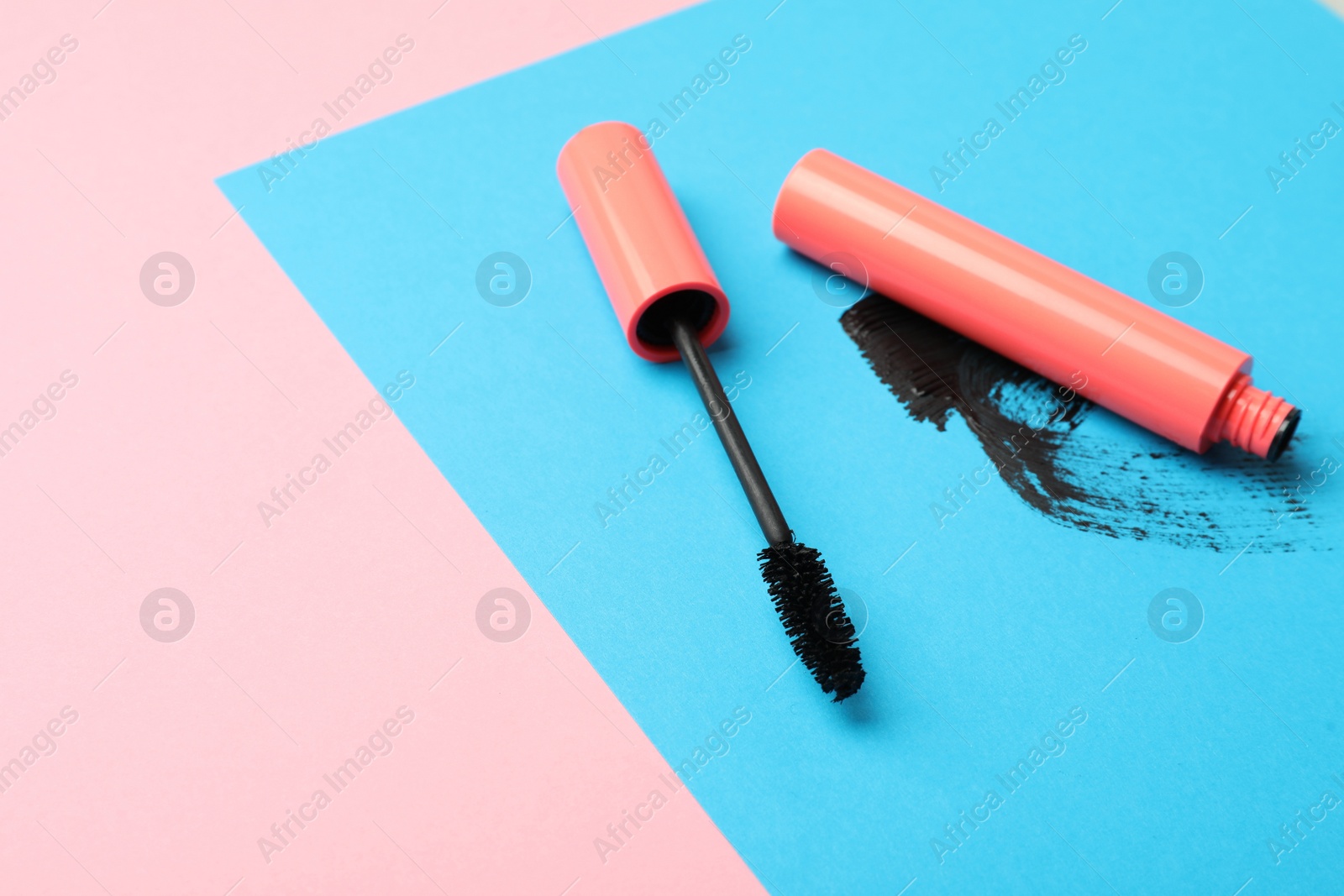 Photo of Mascara and smear on color background, space for text. Makeup product