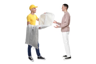 Image of Dry-cleaning delivery. Courier giving garment cover with clothes to man on white background
