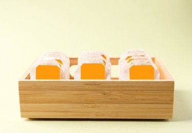 Photo of Wooden box with many tea bags on light green background