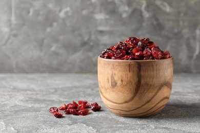 Photo of Bowl of sweet cranberries on table, space for text. Dried fruit as healthy snack