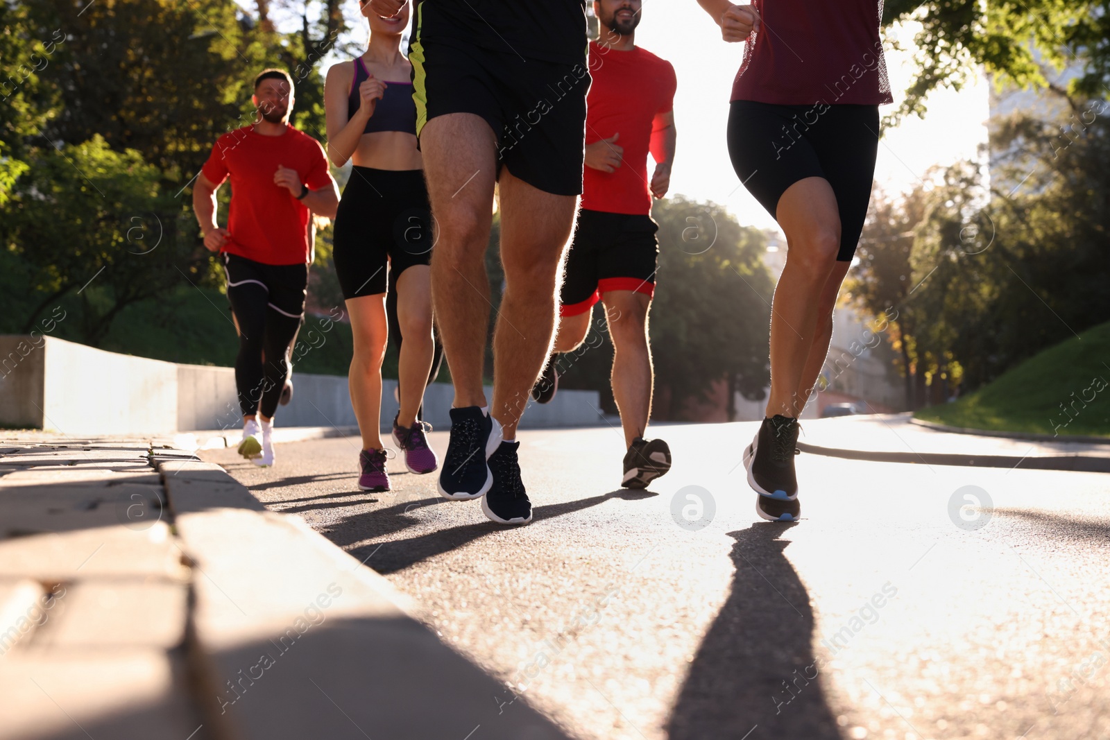 Photo of Group of people running outdoors on sunny day