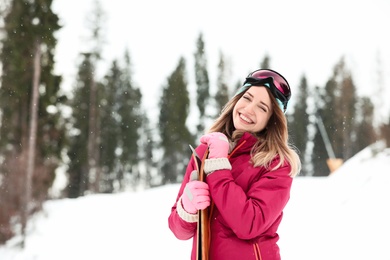 Photo of Female skier on slope at resort, space for text. Winter vacation