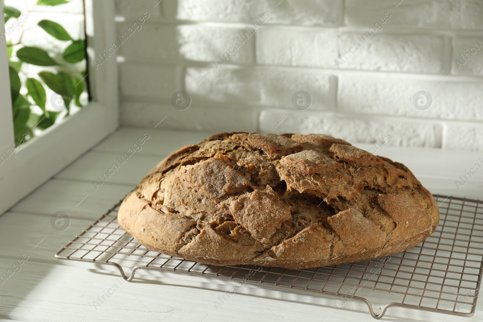 Photo of Freshly baked sourdough bread on white wooden table indoors