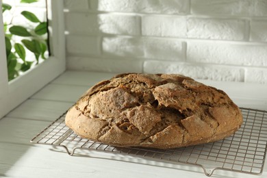 Freshly baked sourdough bread on white wooden table indoors