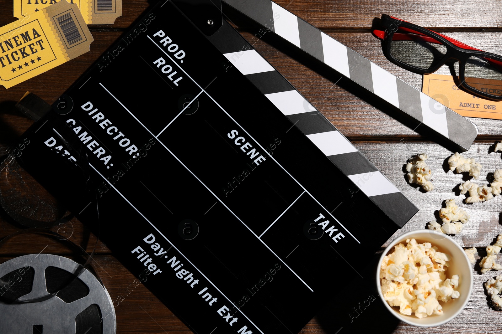 Photo of Flat lay composition with clapperboard and popcorn on wooden table