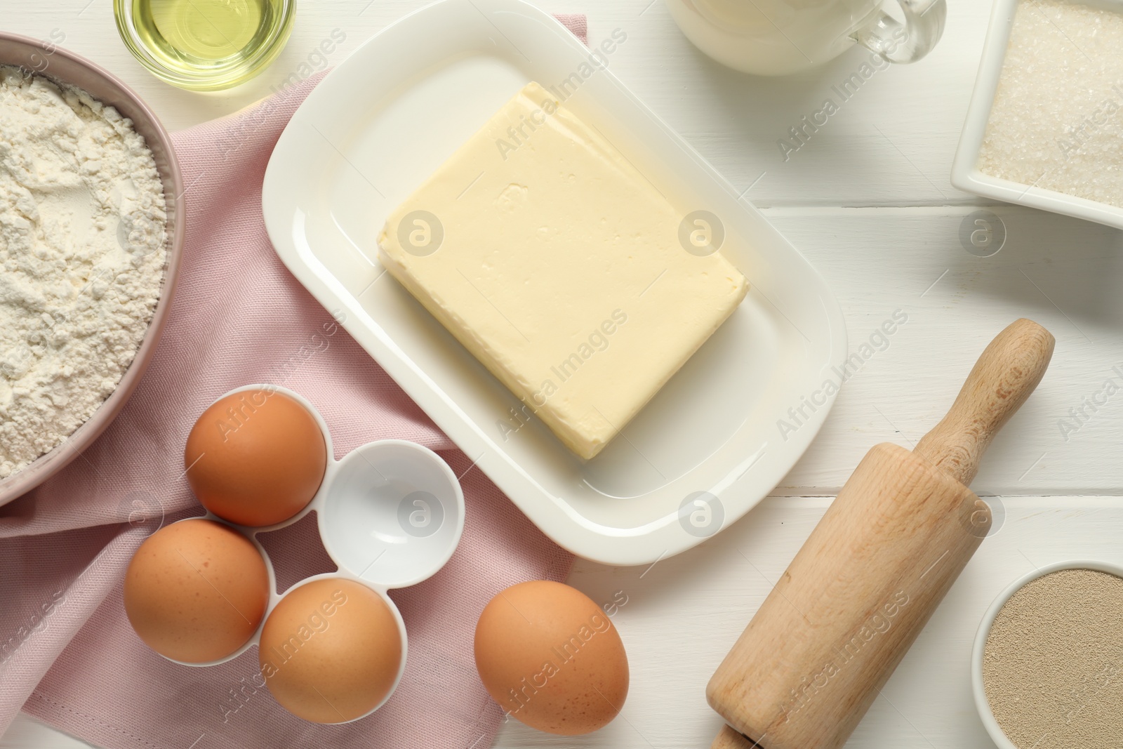 Photo of Flat lay composition with fresh butter and other products on white wooden table