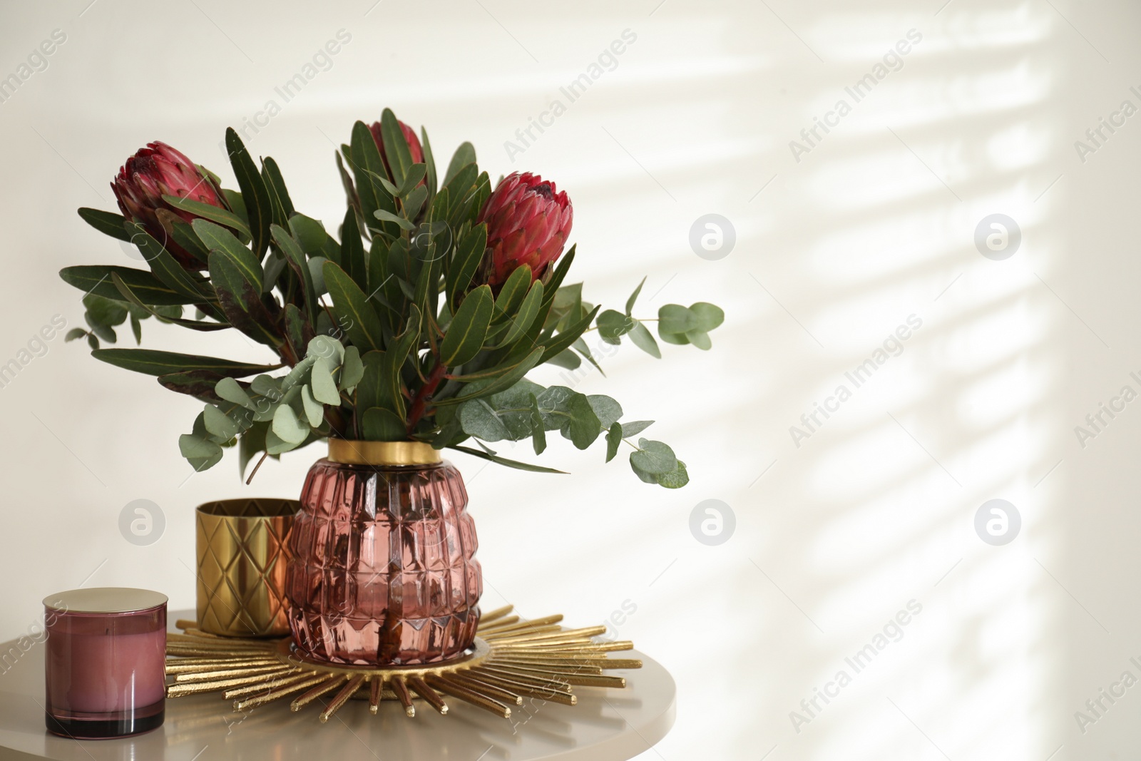 Photo of Vase with bouquet of beautiful Protea flowers on table indoors