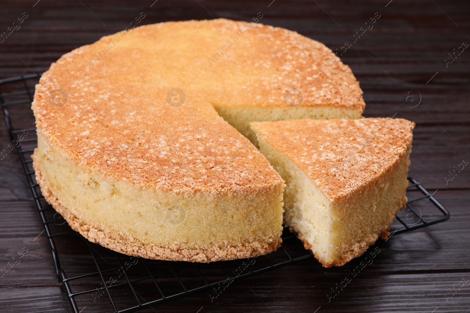 Photo of Tasty sponge cake on wooden table, closeup