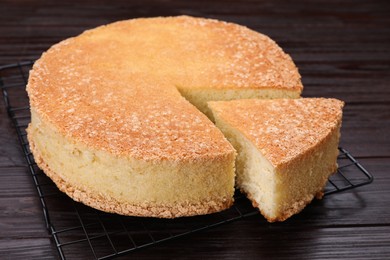 Photo of Tasty sponge cake on wooden table, closeup