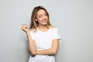 Portrait of young woman with beautiful face on grey background