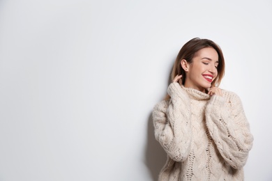 Photo of Beautiful young woman in warm sweater on white background. Space for text