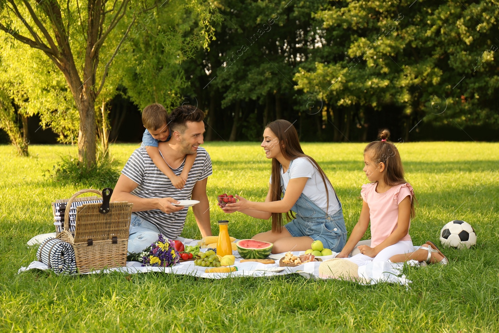 Photo of Happy family having picnic in park on sunny summer day