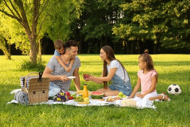 Happy family having picnic in park on sunny summer day