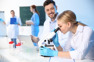 Group of scientists working in modern chemistry laboratory