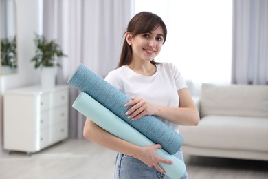 Photo of Woman with light blue wallpaper rolls in room