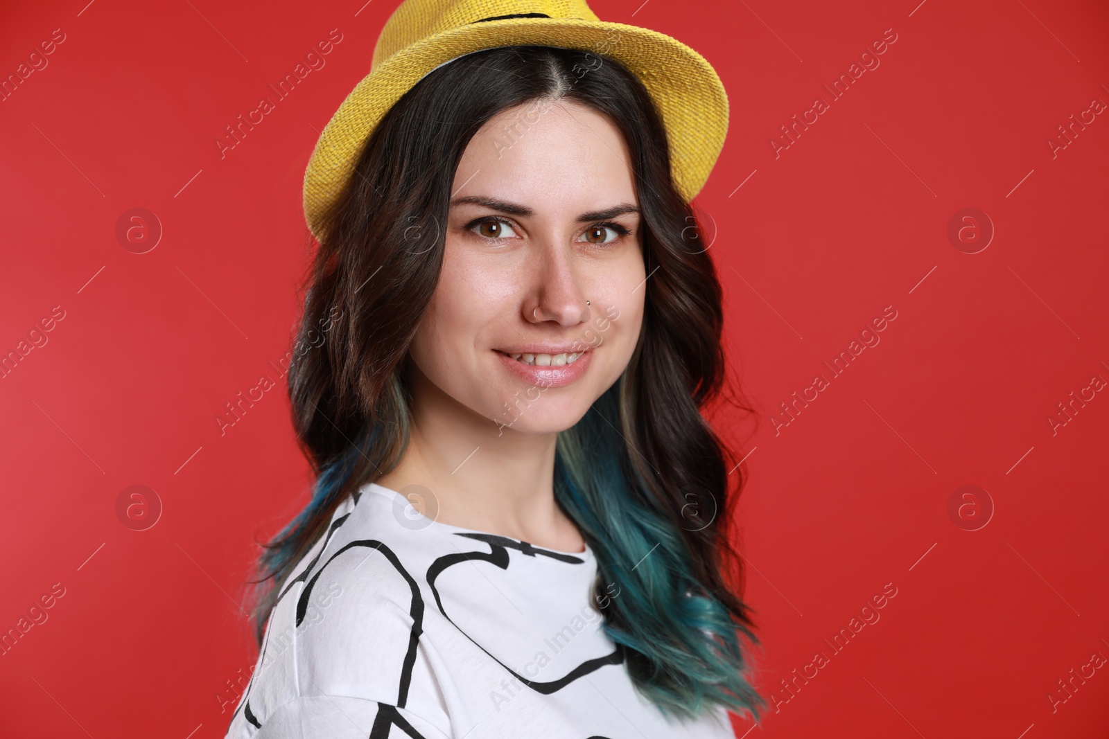 Photo of Beautiful young woman with nose piercing on red background