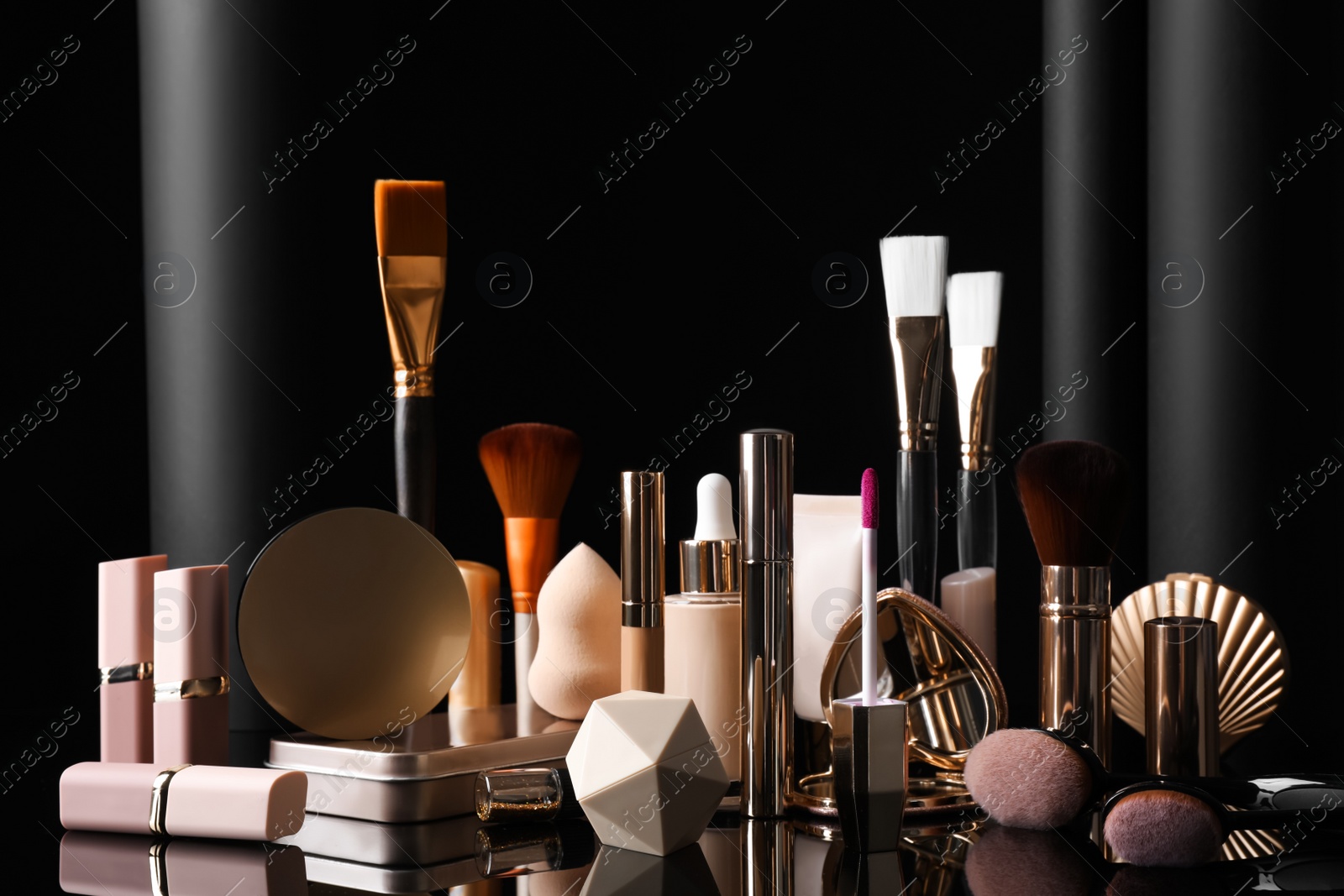 Photo of Composition with makeup products on table against black background