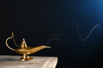 Aladdin magic lamp on table against dark background