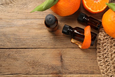 Photo of Flat lay composition with tangerine essential oil on wooden table, space for text