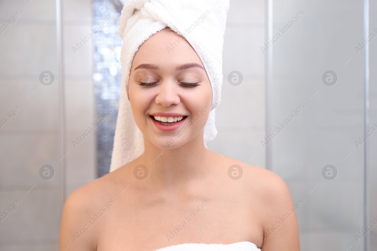 Photo of Portrait of beautiful woman with towel on head in bathroom