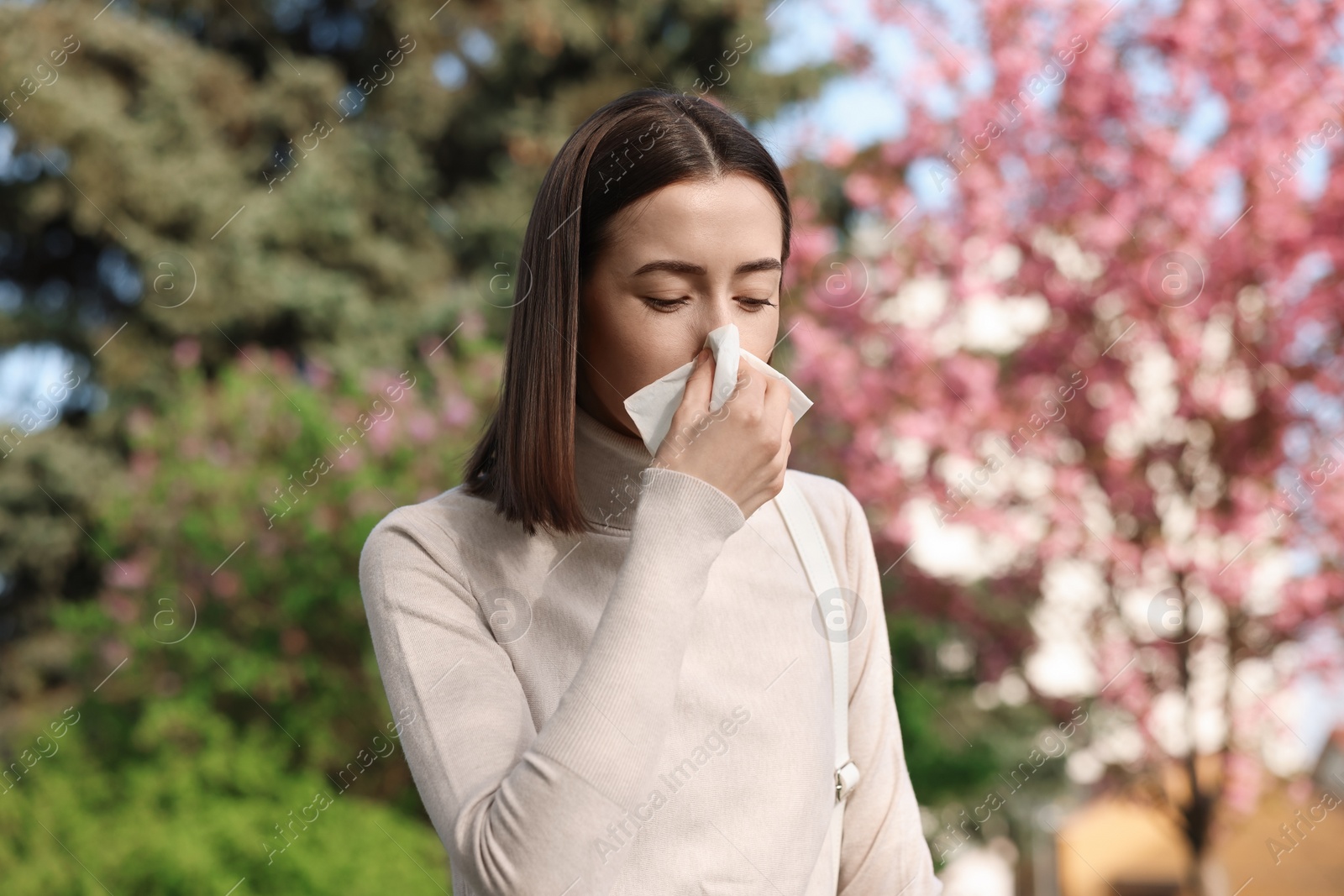 Photo of Woman with napkin suffering from seasonal allergy on spring day