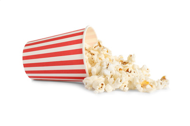 Photo of Overturned paper cup with delicious popcorn isolated on white