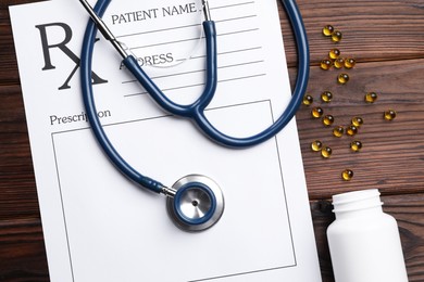 Photo of Medical prescription form with empty fields, stethoscope and pills on wooden table, flat lay