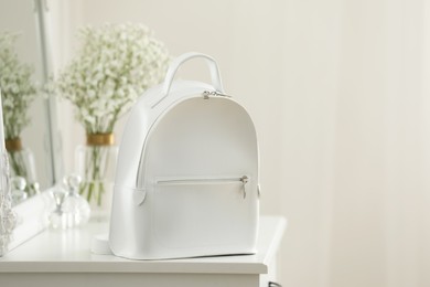 Stylish white backpack on table indoors, space for text