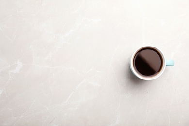 Photo of Ceramic cup with hot aromatic coffee on marble background, top view