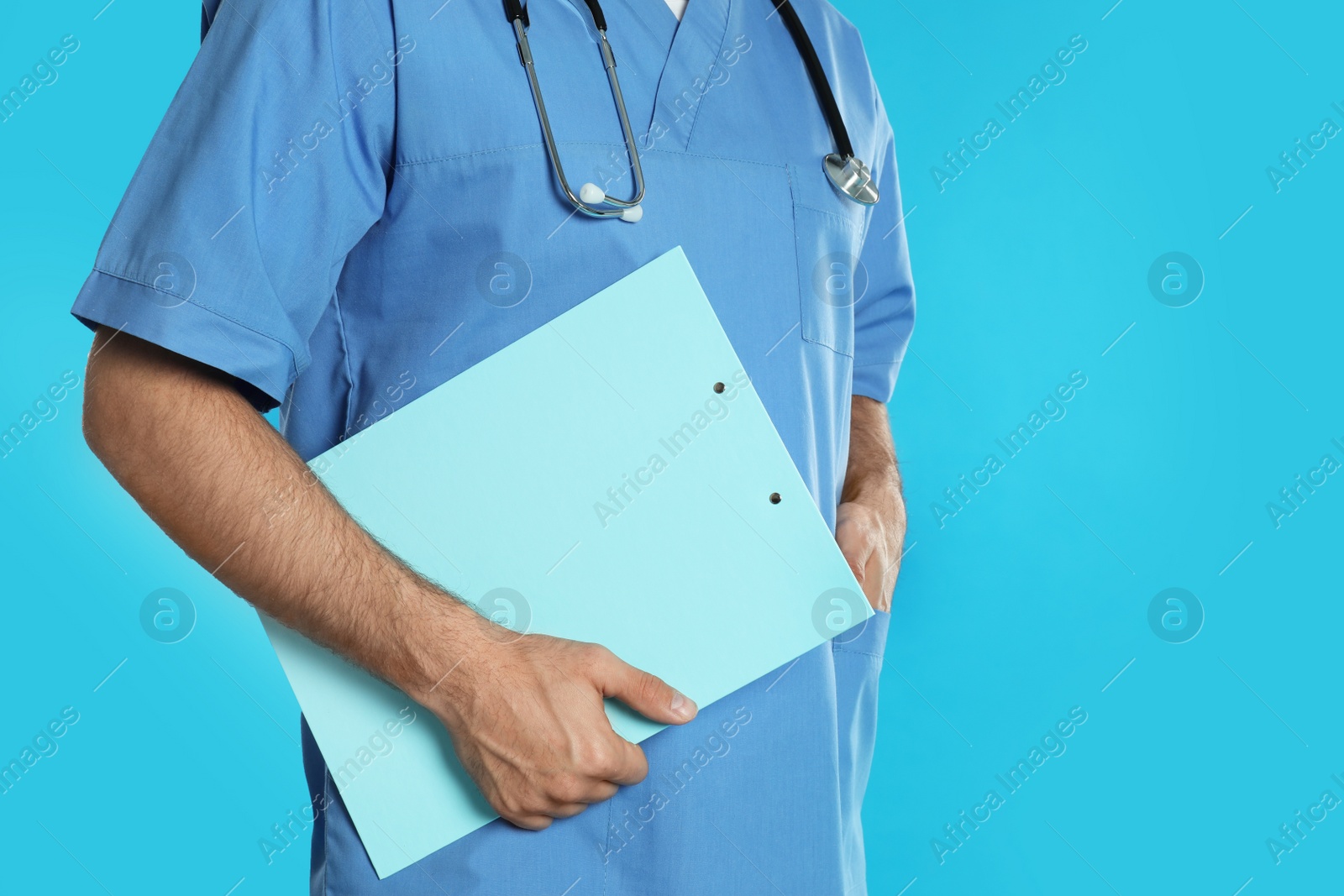 Photo of Doctor with clipboard on blue background, closeup