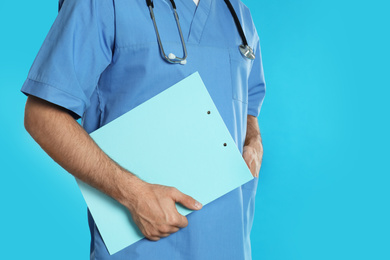 Doctor with clipboard on blue background, closeup