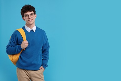 Portrait of student with backpack on light blue background. Space for text
