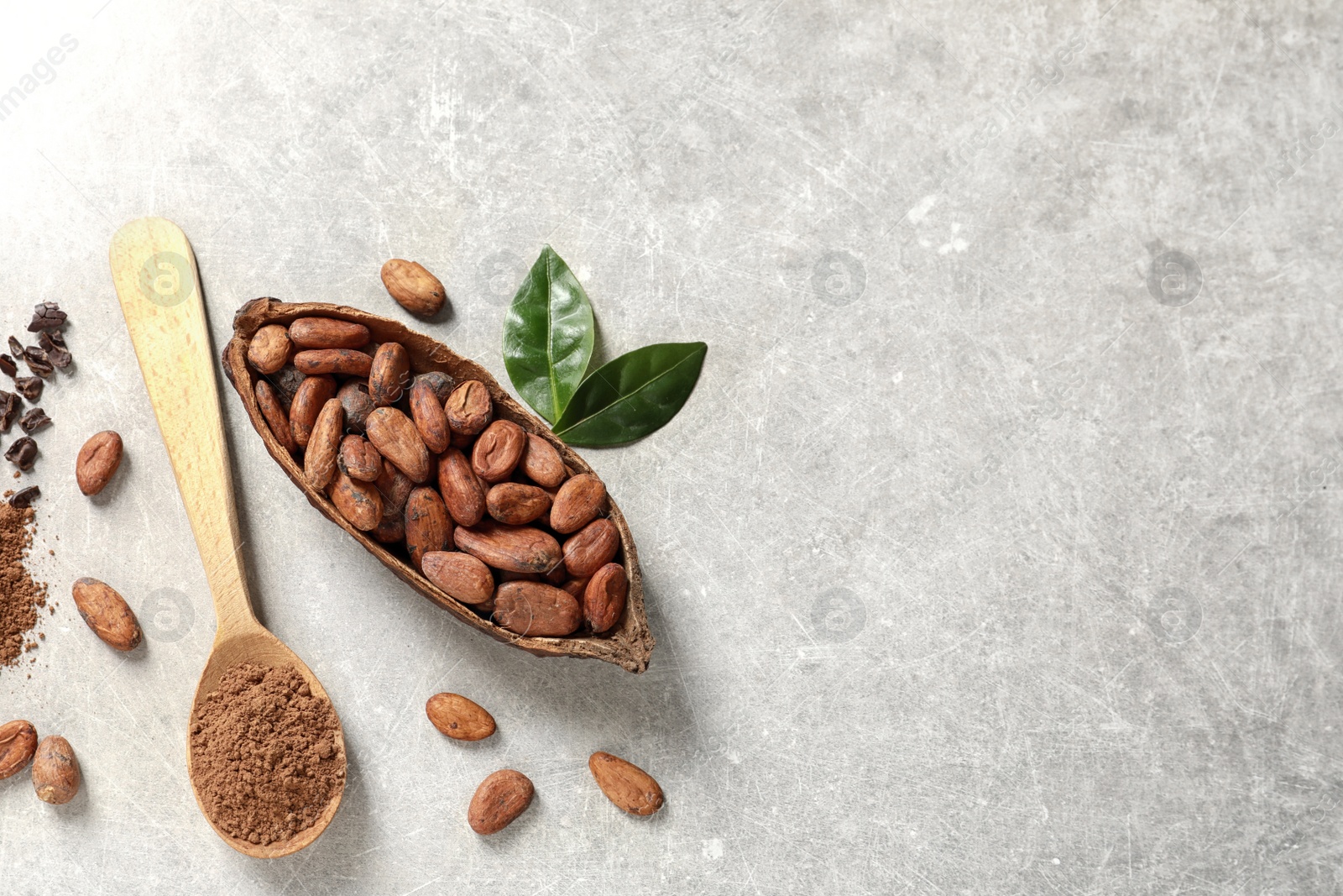 Photo of Cocoa pod, beans and powder on light table, flat lay. Space for text