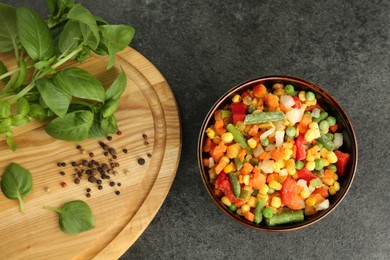 Photo of Different frozen vegetables, spices and fresh basil on grey table, flat lay