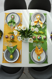 Photo of Festive Easter table setting with beautiful tulips and eggs, top view