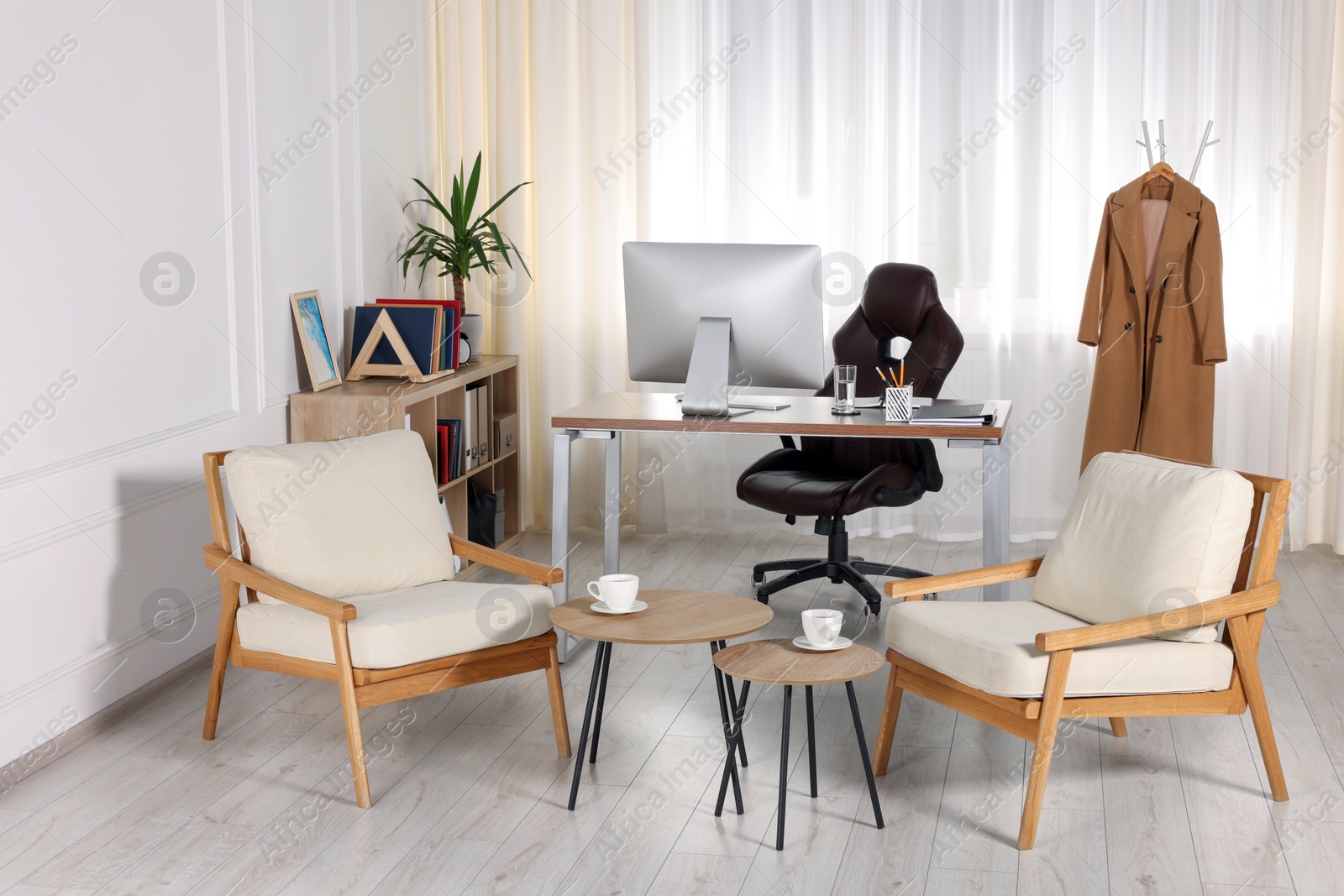 Photo of Receptionist workplace with computer and waiting area. Interior design