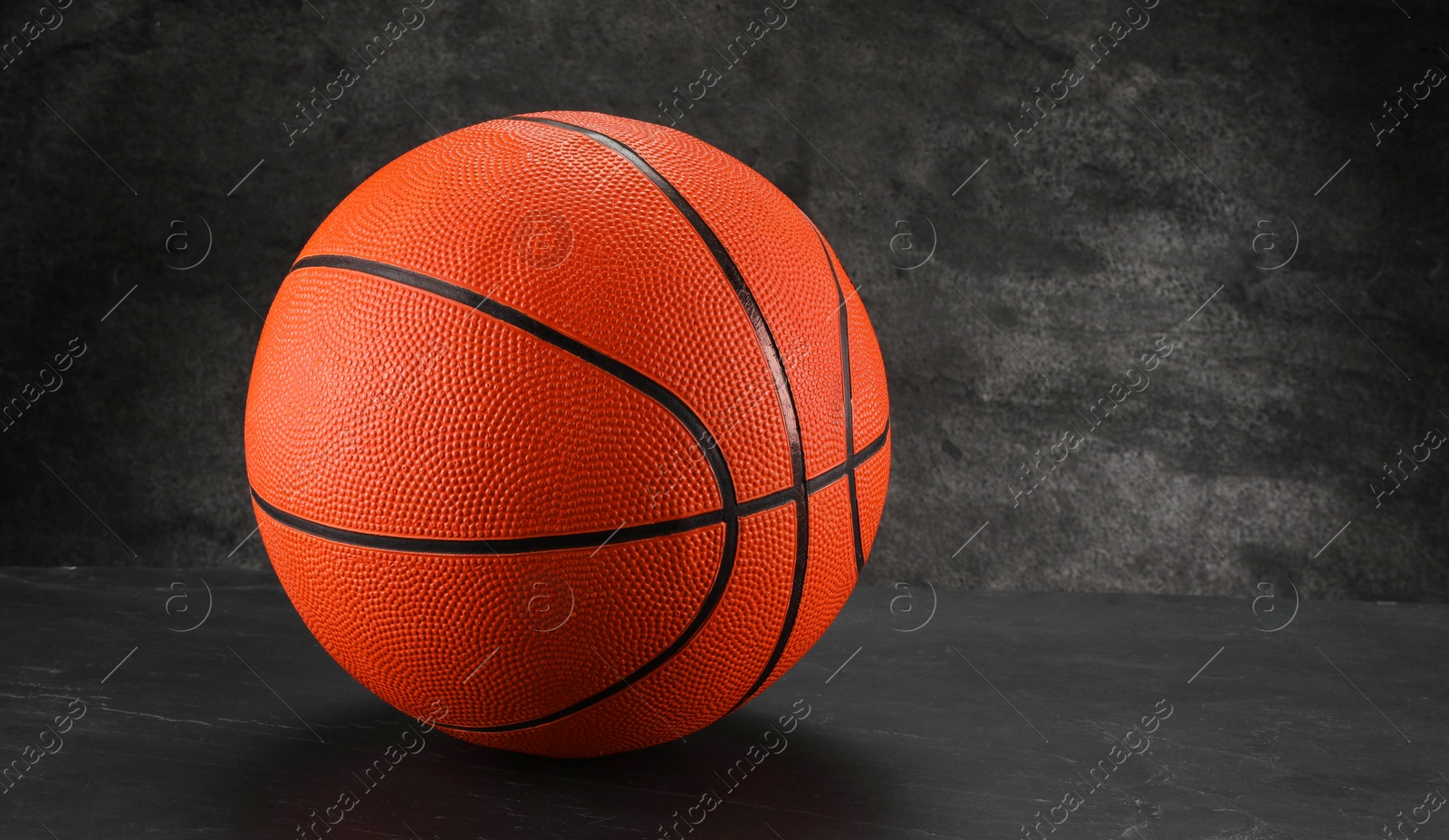 Photo of Basketball ball on dark gray background, space for text