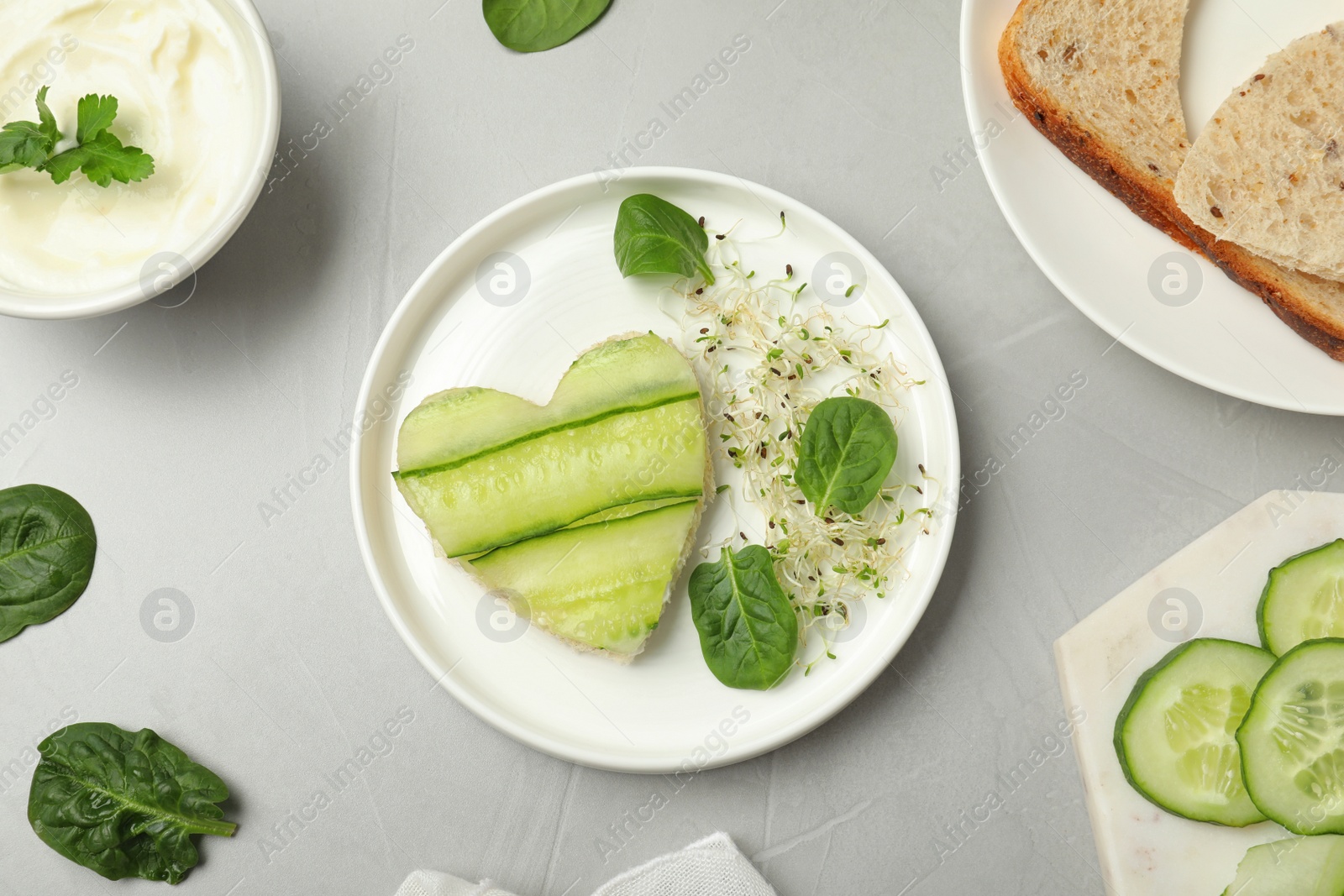 Photo of Flat lay composition with traditional English cucumber sandwich and ingredients on grey background