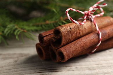 Photo of Cinnamon sticks on wooden table, closeup view