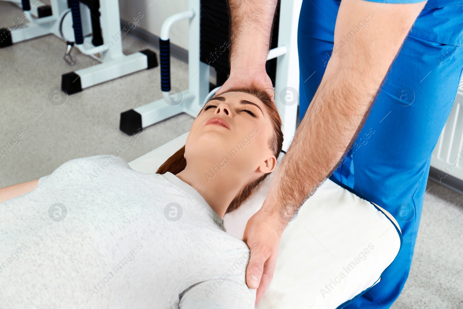 Photo of Physiotherapist working with patient in rehabilitation center