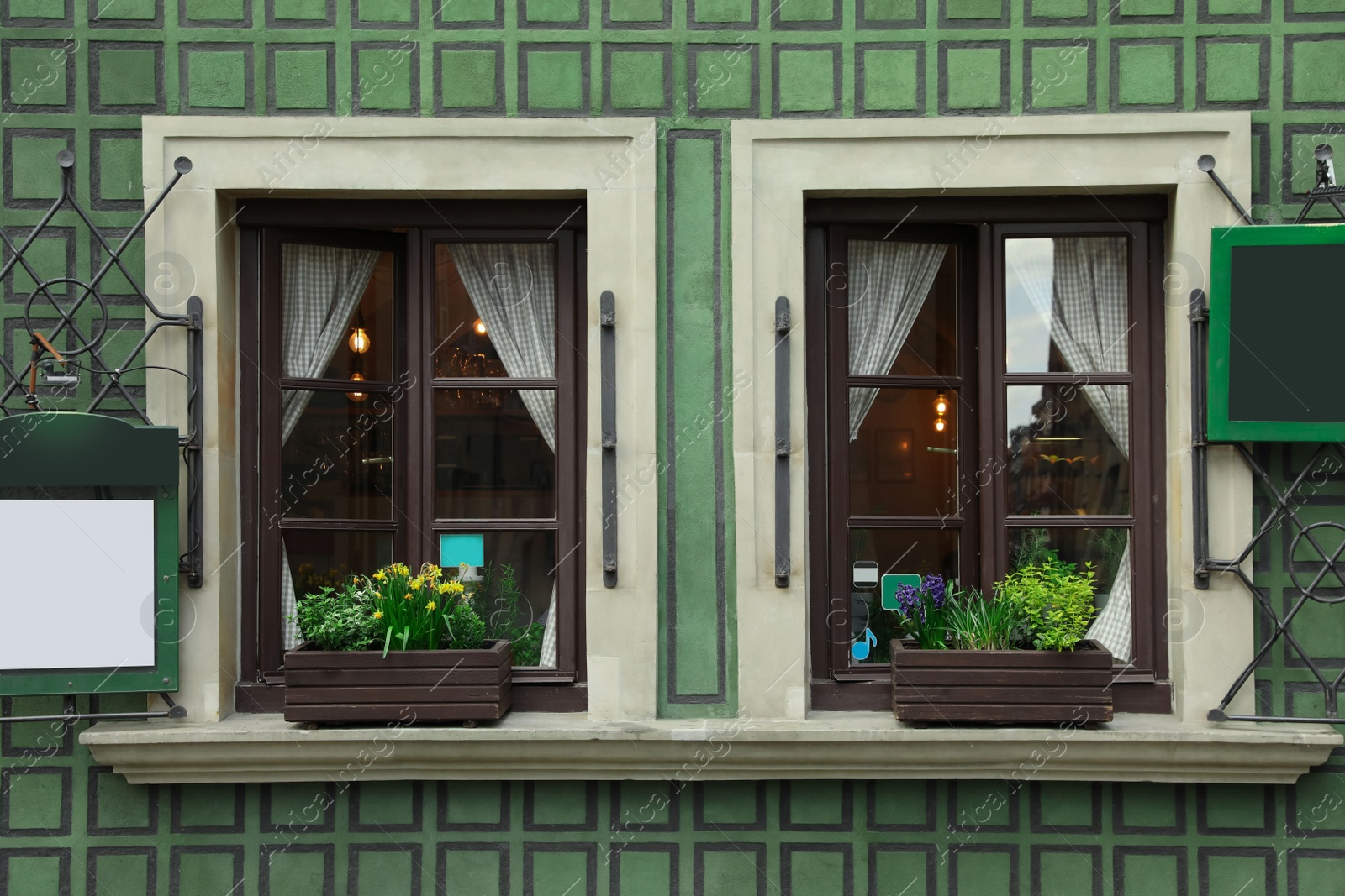 Photo of Building with open windows and flower decor, view from outdoors