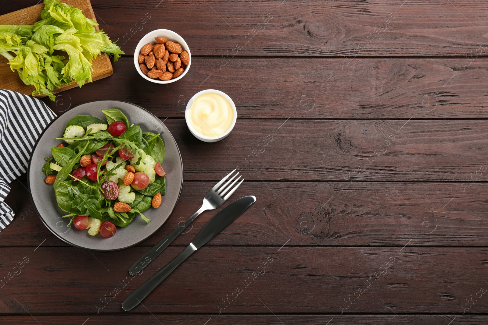 Photo of Delicious fresh celery salad served on wooden table, flat lay. Space for text