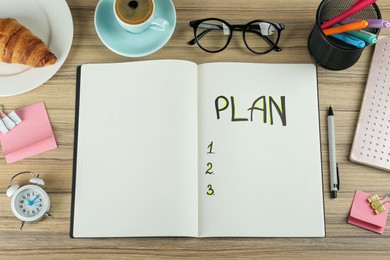 Photo of Flat lay composition of notebook with plan list on wooden table