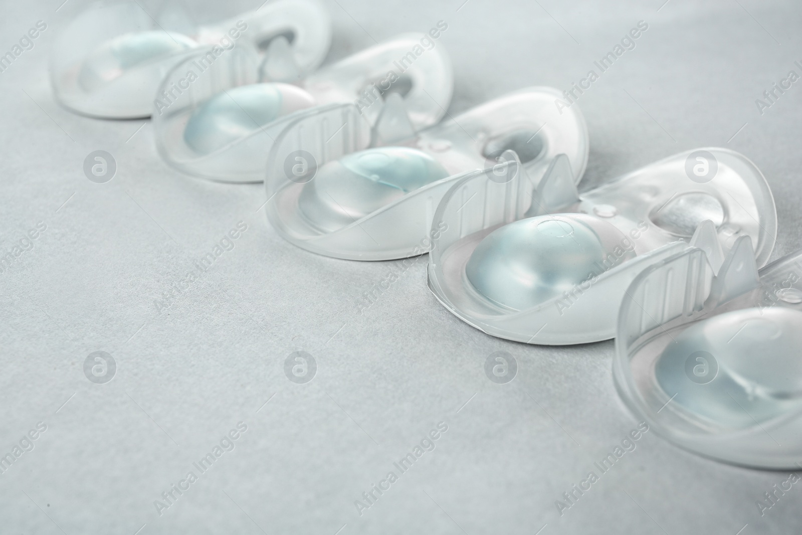 Photo of Packages with contact lenses on light background