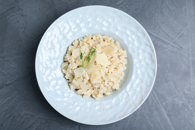 Photo of Delicious risotto with cheese on grey table, top view