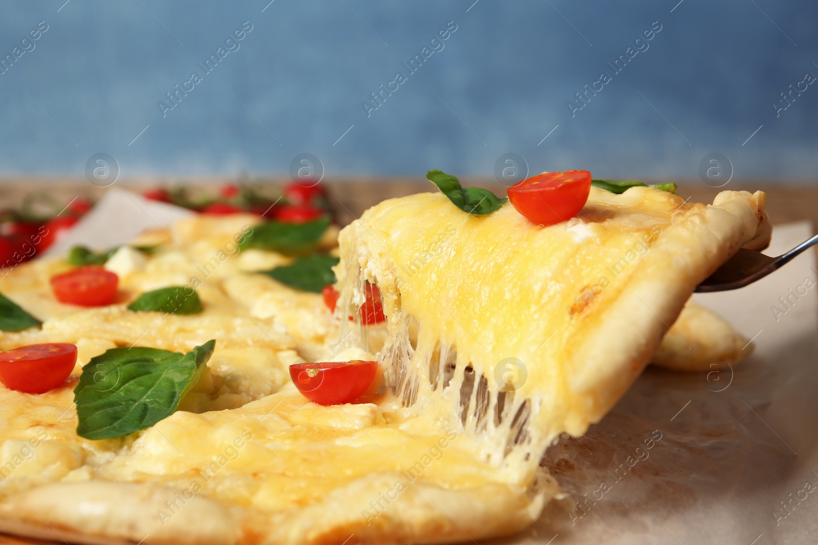 Photo of Taking tasty homemade pizza slice with melted cheese, closeup